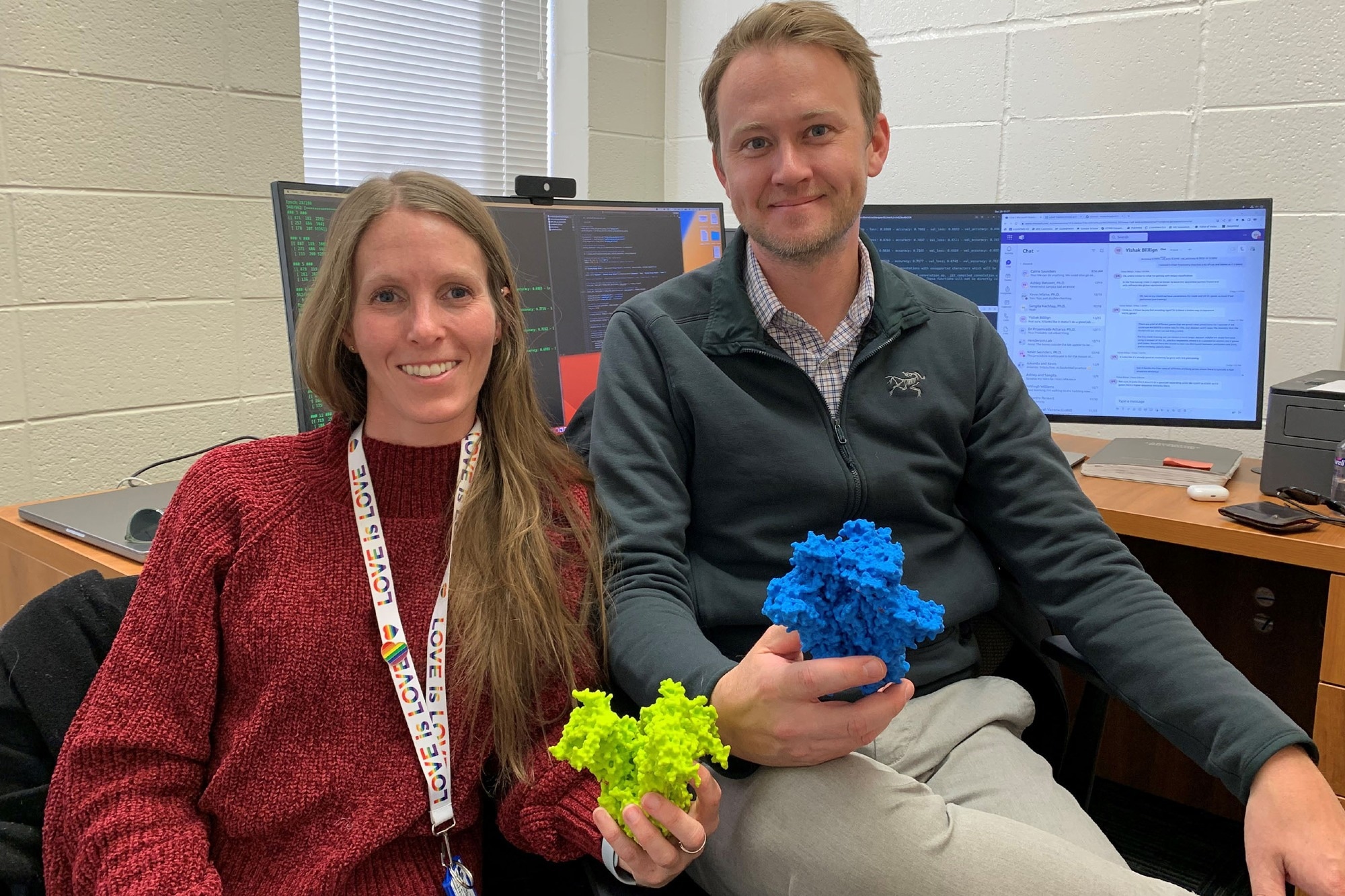 Postdoctoral researcher Ashley Bennett (left) and Associate Professor Rory Henderson of the Duke Human Vaccine Institute with 3D printed models of the molecules they study on the HIV virus